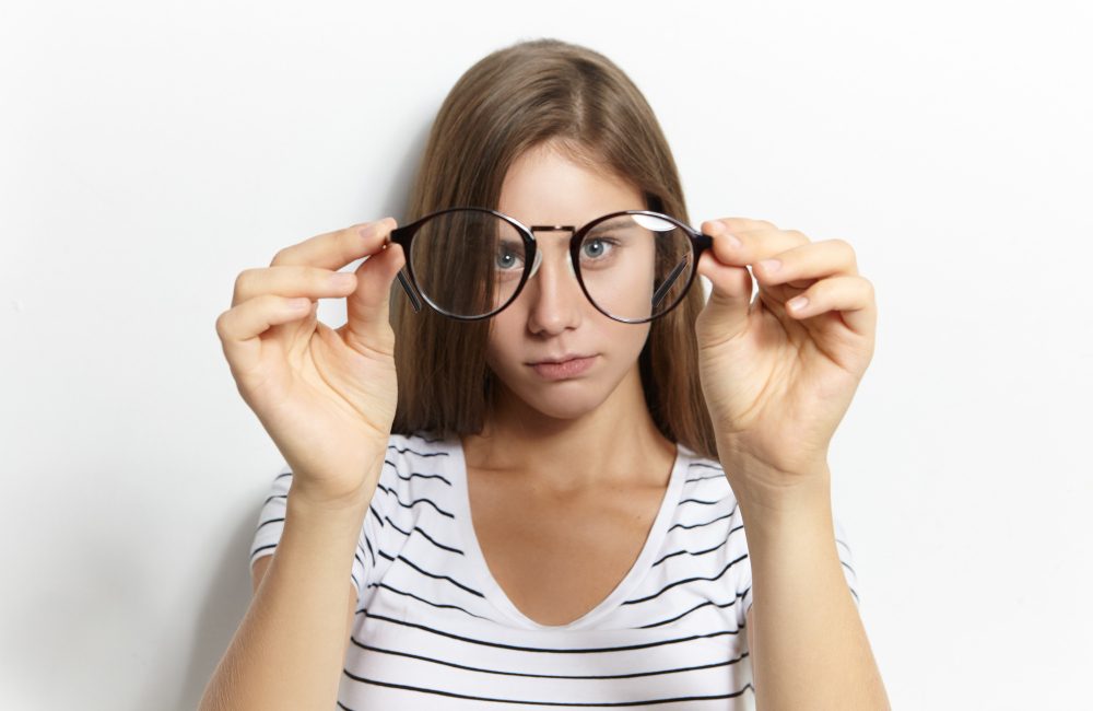chica con astigmatismo llevando gafas que se quiere operar